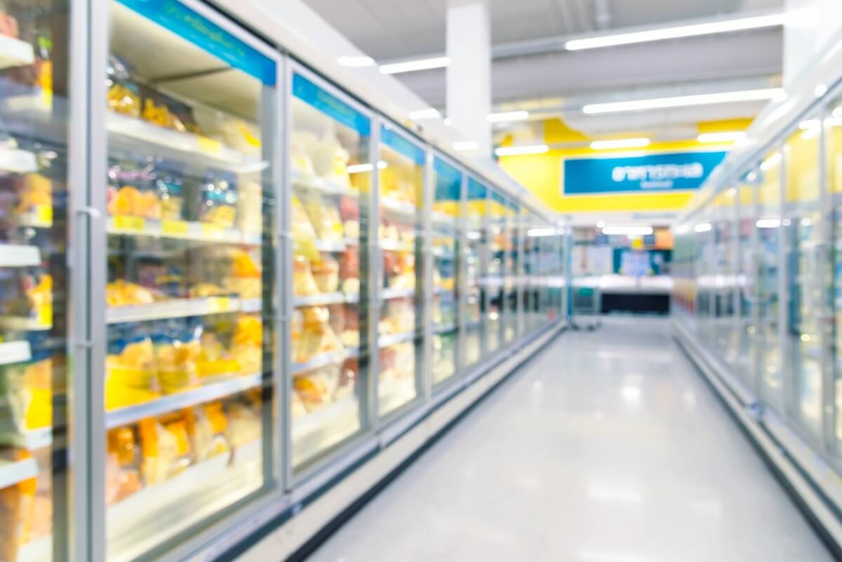 Grocery aisle with freezers containing frozen foods